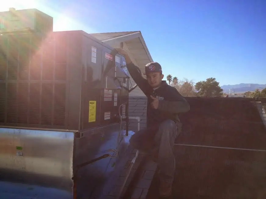 HVAC technician performing Heat Pump Repair on a rooftop unit in Hammond